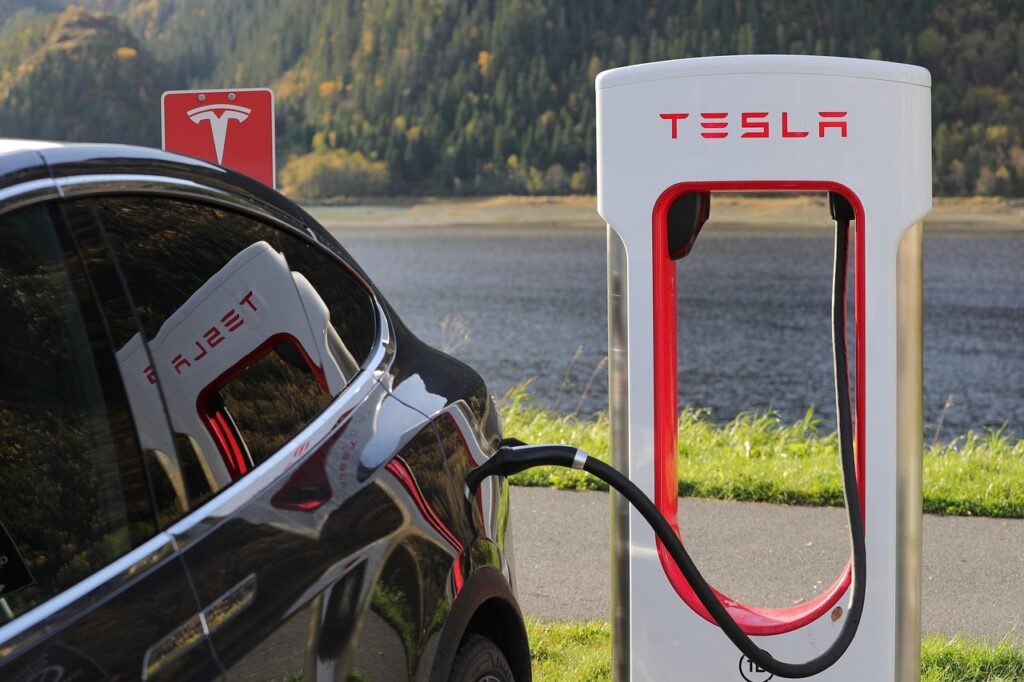 a car being charged by a tesla super charger